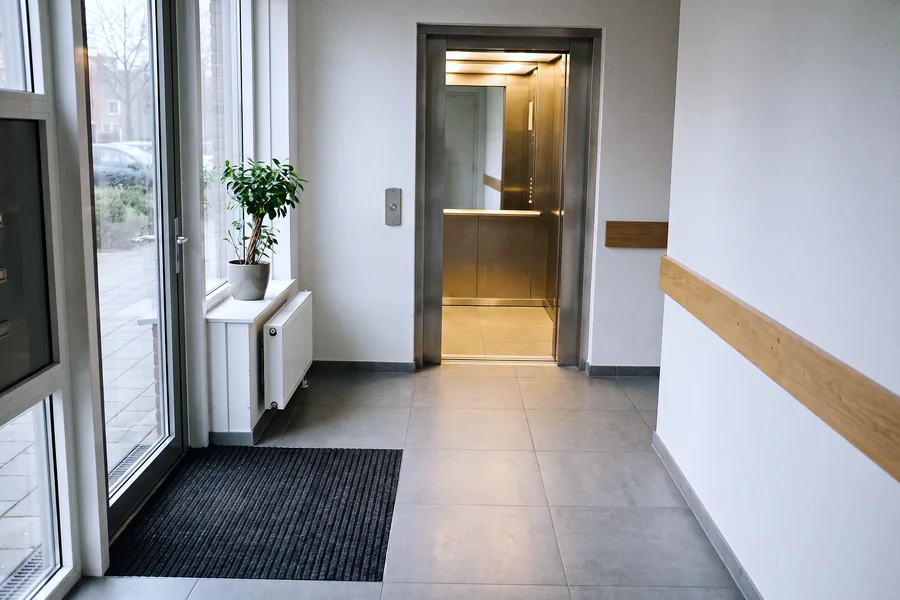 Een entreehal zonder treden met een open lift.