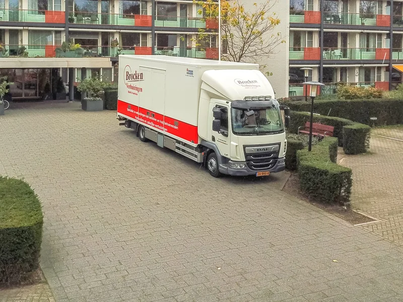 Luchtfoto van een appartementencomplex met de verhuiswagen van Brocken Verhuizingen voor de ingang