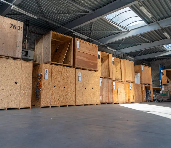 Rijen genummerde houten opslagkisten in de opslaghal van Brocken Verhuizingen