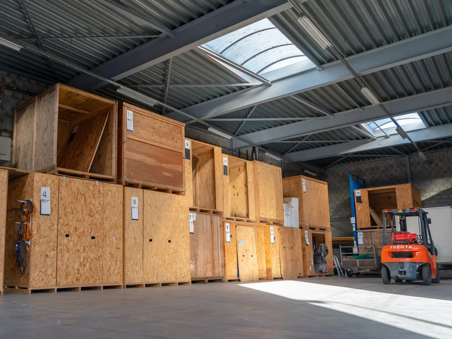 De opslaghal van Brocken Verhuizingen met genummerde houten opslagkisten en een heftruck