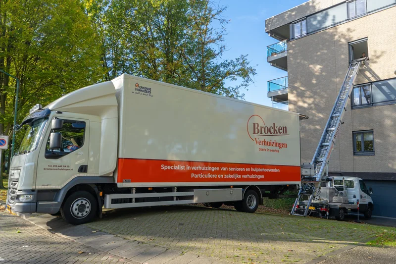 Verhuiswagen van Brocken Verhuizingen met een ladderlift tot aan een raam van een appartementengebouw